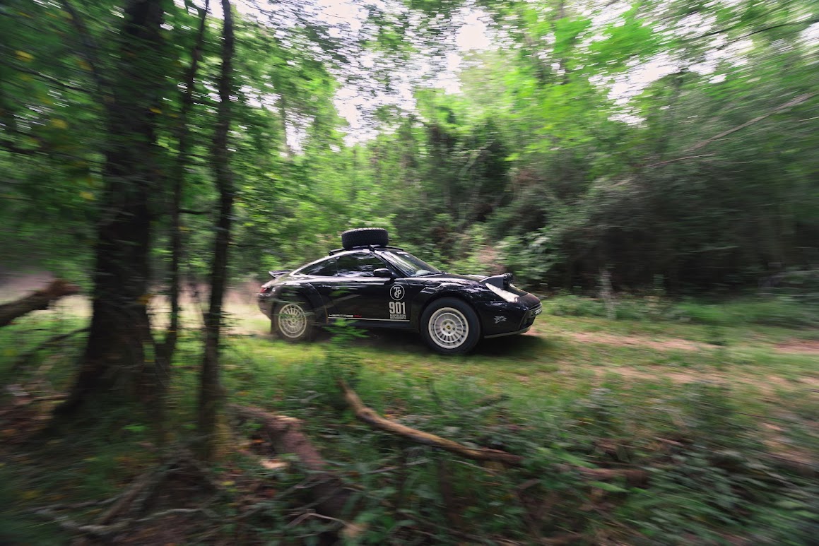 Black 911 Heritage RX moving quickly through a forest road